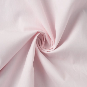 Macro shot of high-quality light pink cotton fabric showing soft texture and fine drape