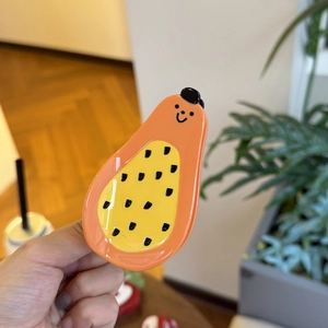 Cute papaya-shaped ceramic fruit spoon with playful seeds and smiley face handle