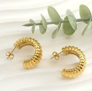 Vue détaillée des boucles d'oreilles croissant en or 18 carats avec des rainures verticales