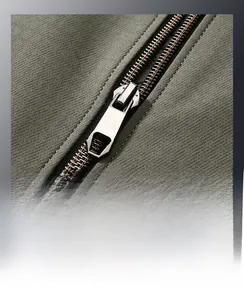 Close-up of premium metal zipper on olive green stand collar jacket with windproof fabric