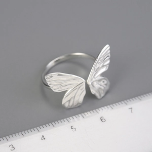 Adjustable S925 sterling silver butterfly open ring displayed over a measurement scale
