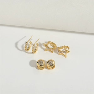 Set of gold pentagram earrings and huggie hoops featuring white zircon pavé details