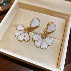Boucles d'oreilles pendantes pétales de fleurs dorées avec émail blanc élégant