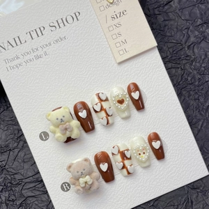 Detail of coffee brown press-on nails with 3D flocked bears and pearl hearts