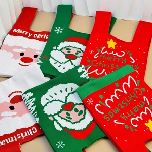 Flat lay of colorful knit Christmas tote bags with Santa and snowflake patterns