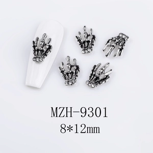 Macro view of skeleton hand nail charms with silver finish and sparkling rhinestones