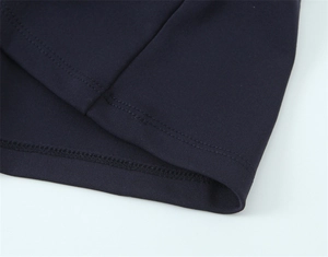 Gros plan sur l'ourlet à double surpiqûre et la texture du tissu d'une robe longue marine