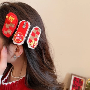 Détail de pinces à cheveux rouges festives avec motifs de danse du lion et charms