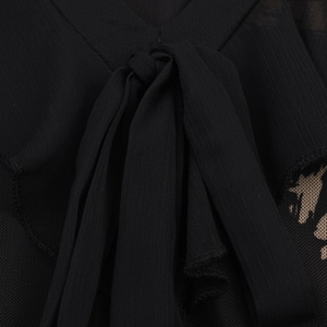 Close-up of black bow tie neckline on an elegant bodycon dress with ruffle details