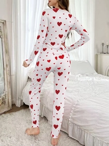 Detail of ribbed texture and red heart print on white long-sleeve pajama set fabric