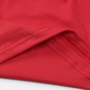 Detailed close-up of double-needle stitching on the red knit fabric of the mini dress