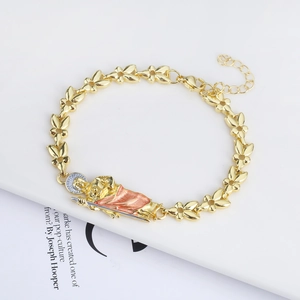 Detailed macro view of 18K gold religious bracelet with San Judas enamel pendant