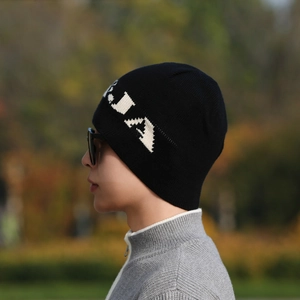 Thick black ribbed knit beanie with white letter jacquard on a male model for winter