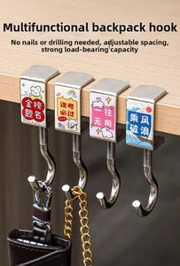 Detail of adjustable metal bag hook with cartoon pattern on a wooden desk edge