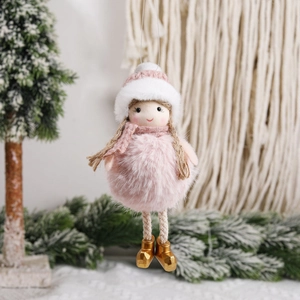 Charming pink plush Christmas doll ornament with gold boots on a snowy holiday tree
