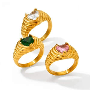 Close-up of heart-cut zircon rings with gold textured bands in pink green and white