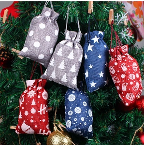 Weihnachts-Jutebeutel mit Kordelzug und festlichen Drucken an Tannenzweigen für die Dekoration