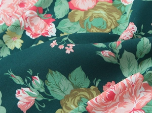 Close-up of vintage dark green floral fabric with rose print and chiffon texture