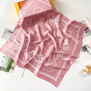 Detailed view of pink paisley satin scarf texture with elegant floral patterns on white