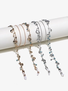 Goldene und silberne Brillenketten mit Muschel-Anhängern und blauen Strasssteinen auf Halter