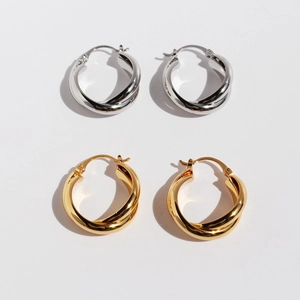 Klassische goldene und silberne gedrehte Creolen mit minimalistischem Metall-Design