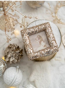 Close-up of golden square photo frame with sequins and stars in Christmas decor