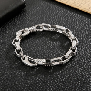 Close-up of vintage industrial steel chain bracelet with diagonal engraved square links
