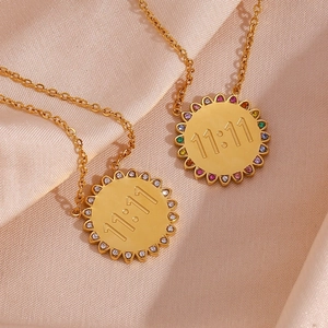 Macro shot of 18K gold plated necklaces with 11:11 engraving on champagne silk