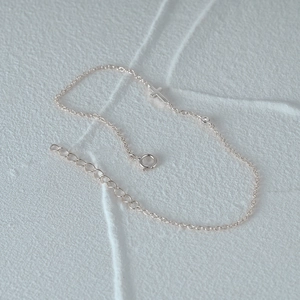 Close-up of 925 silver cross bracelet with small round diamond and adjustable chain