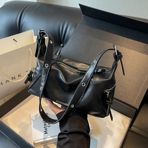 Black leather Boston tote bag with metal eyelet strap shown in a premium gift setting