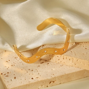 Détail du bracelet ondulé plaqué or 18 carats avec des strass incrustés en forme d'étoile