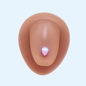 Close-up of pink iridescent teardrop earring on silicone ear model with blue background