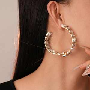 Close-up of gold C-shaped hoop earrings with square rhinestones on model