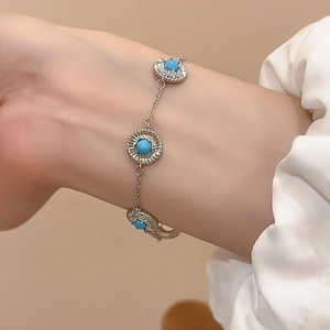 Détail du bracelet argenté avec maillons tournesol et incrustations de pierres bleues