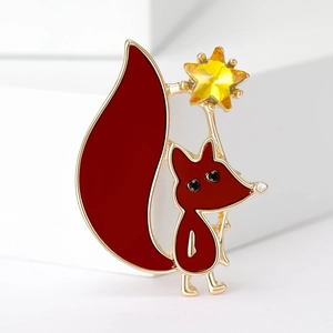 Detail of red fox brooch with golden metal edges and a yellow crystal star wand