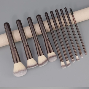 Macro view of 10 professional makeup brushes with brown handles and gradient bristles
