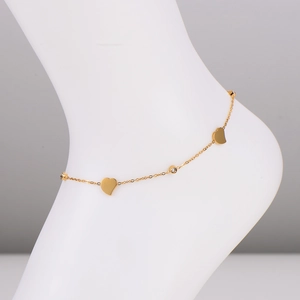 Bracelet de cheville cœur doré minimaliste avec diamants sur un pied de modèle