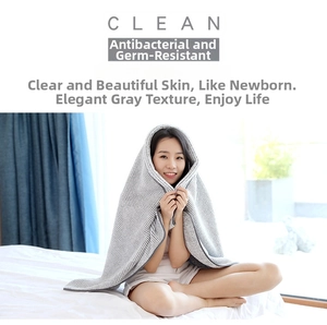 Detail of soft charcoal fiber bath towel with grey stripes used as a cozy shawl wrap