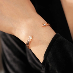 Gros plan détaillé du bracelet jonc doré rose avec motif matelassé et zircons brillants