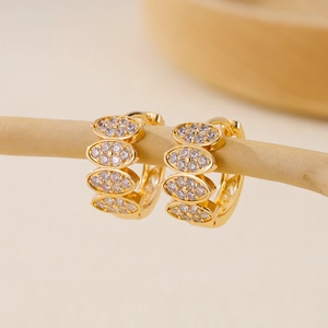 Detail of gold hoop earrings featuring leaf-shaped marquise-cut zircon stones
