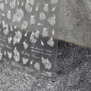 Detailed macro view of 5D white embossed rose nail art stickers with textured finish