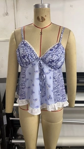 Detail eines floralen Patchwork-Camisoles mit weißem Spitzenbesatz und Schnürung
