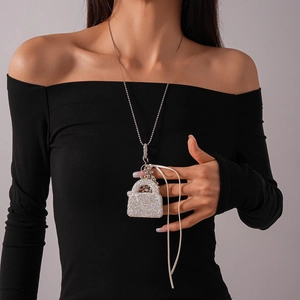 Collier à pendentif sac à main en cristal sur une robe noire pour un look élégant