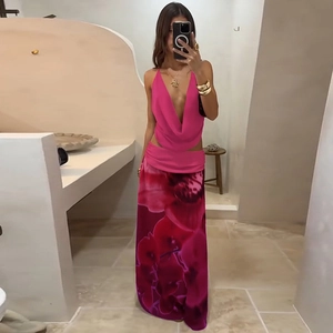Détail du haut dos nu rose rouge et de la jupe longue fleurie avec découpe à la taille