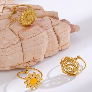 Detailed macro of gold flower rings featuring sunflower, daisy and rose designs