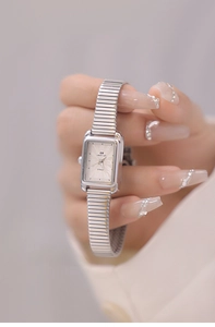 Detail of silver square quartz watch with telescopic metal strap and Roman numerals