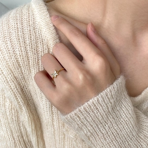 Close-up of golden butterfly ring with marquise-cut zircon stones on a model hand
