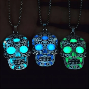 Detailed view of luminous skulls with intricate patterns in cyan, blue, and green light