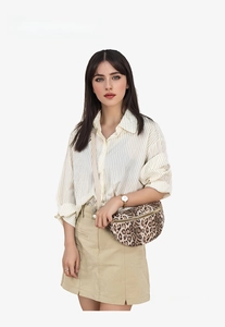 Detail of trendy leopard print crossbody waist bag with adjustable strap on model