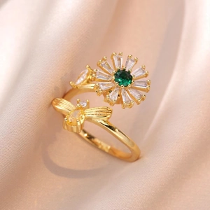 Dettaglio dell'anello girasole dorato con gemma verde e piccola ape decorativa